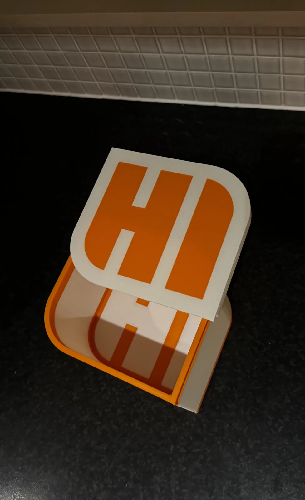Låda med texten HI i orange och vitt